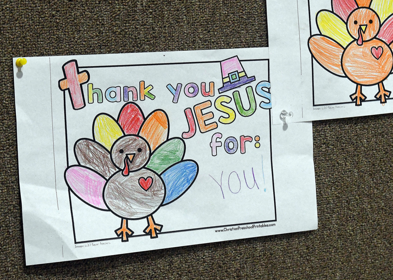 Artwork on a church bulletin board features thank you messages created by church youngsters.